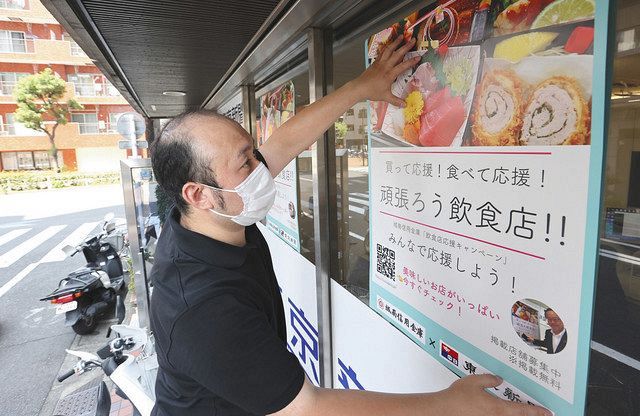 「飲食店応援キャンペーン」のポスターを貼る東京新聞大森西販売所の久保友誉所長