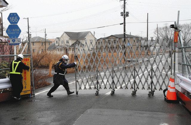 立ち入り規制のゲートを開ける警備員＝1月26日、福島県富岡町で