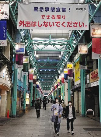 人通りが減った吉祥寺サンロード商店街。頭上には「できる限り外出はしないでください」と書かれた横断幕が掲げられている。＝２６日夕、武蔵野市で