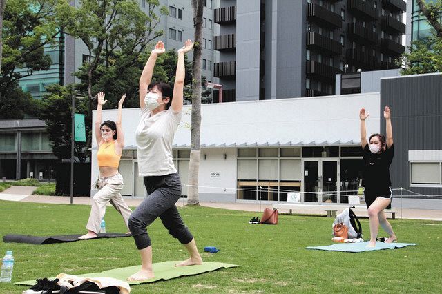 朝ヨガ講座で体を動かす参加者たち＝名古屋市で