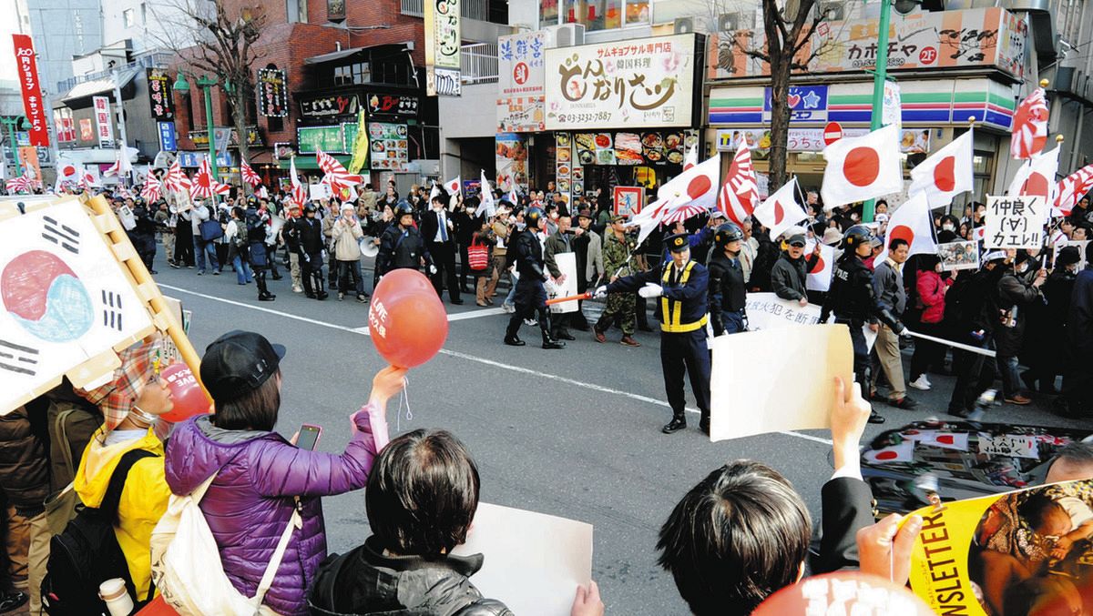 韓流ショップや韓国料理店が並ぶ新大久保で、旭日旗などを掲げてデモ行進する在日特権を許さない市民の会（在特会）＝2013年3月17日、新宿区で