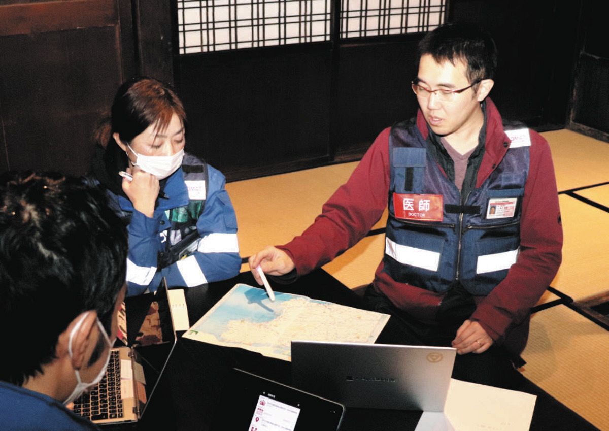 「じろんどん」でミーティングする城戸教裕さん（右）ら福島県いわき市医療センターのDMATメンバー＝石川県能登町で
