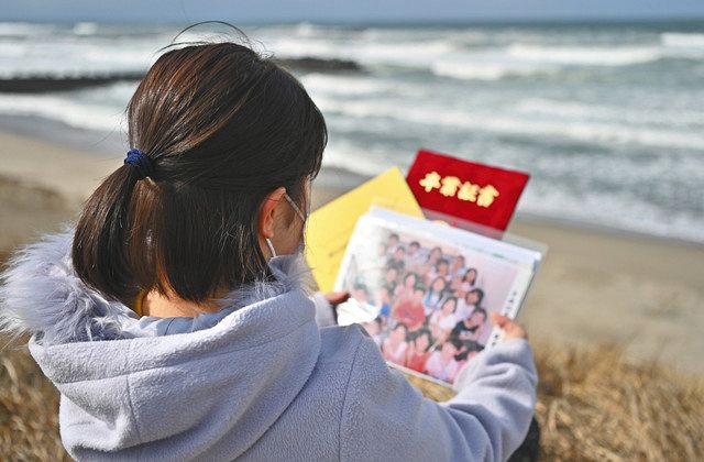 避難前に福島で撮った集合写真や高校の卒業証書を手にする女性。つらいときに海で写真を見ることもあった＝新潟県内で