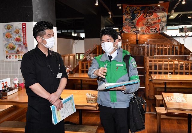 2021年4月、飲食店に立ち入り、コロナ対策のチェック項目を確認する都職員㊨＝東京都新宿区