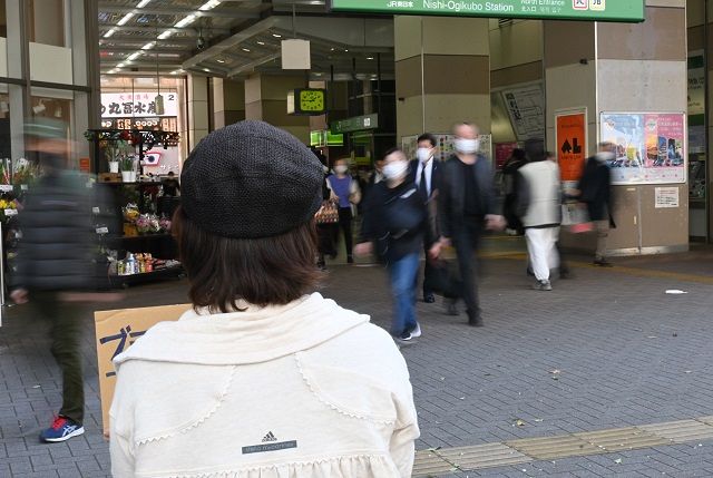 段ボールのプラカードを手に西荻窪駅前に立つ芹沢さん。杉並区長選挙の「ひとり街宣」でも同じ場所に立った