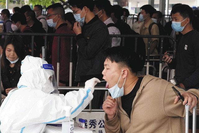 新型コロナウイルスの検査を受ける男性＝25日、中国・広州で（AP）
