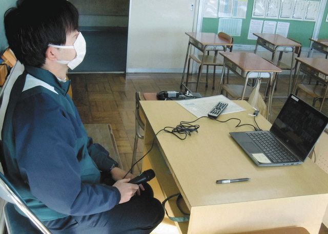 パソコンに向かってクラスの生徒に出席を取る教員。写真右側には大画面モニターも設置されている＝西東京市で（田無第四中学校提供）