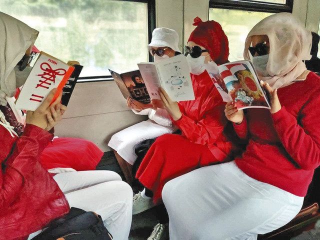 反体制派を象徴する赤と白の服を着てＳＦ小説「１９８４年」などを読むベラルーシ市民＝ゼルカロ提供