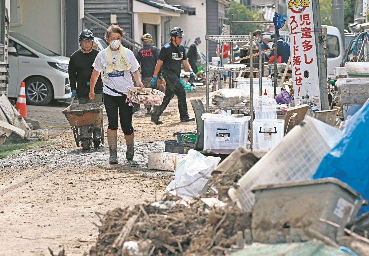 大雨による冠水から1週間後、石川県輪島市で片付けに追われる住民ら