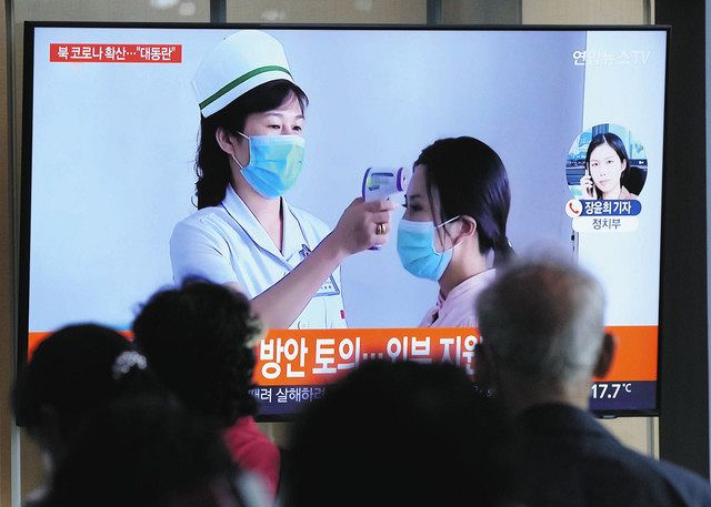 北朝鮮での新型コロナ感染急拡大について報じたニュースを見る、韓国の人々＝14日、ソウル市内で（AP）
