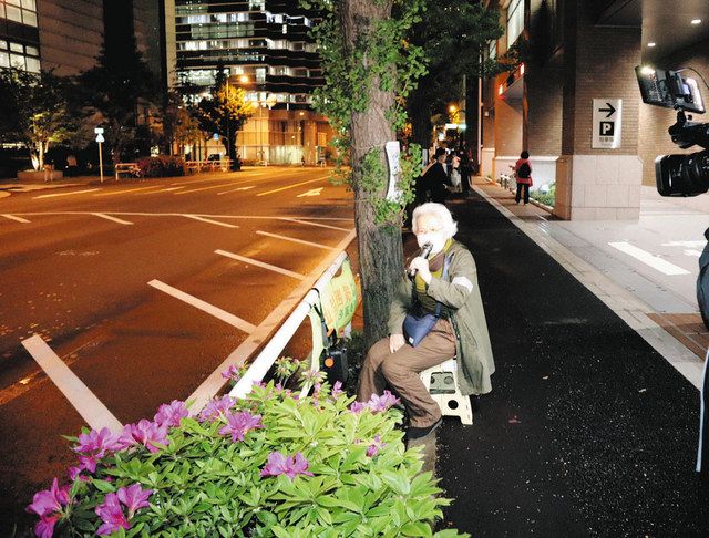 イチョウの前に座り込んで抗議する住民＝２６日、東京都千代田区で