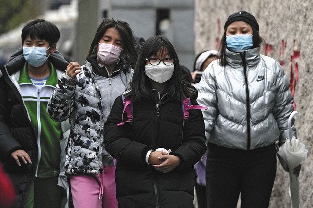 29日、北京市内でマスクを身に着けて下校する生徒ら＝AP