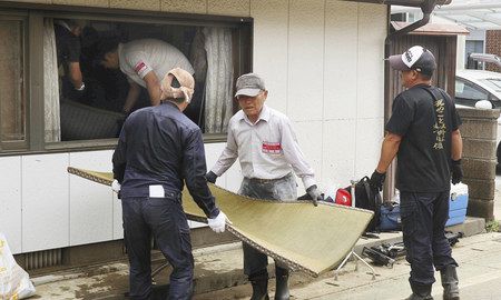 大雨による浸水被害を受けた佐賀県大町町の住宅から畳を運び出すボランティア＝３１日午前