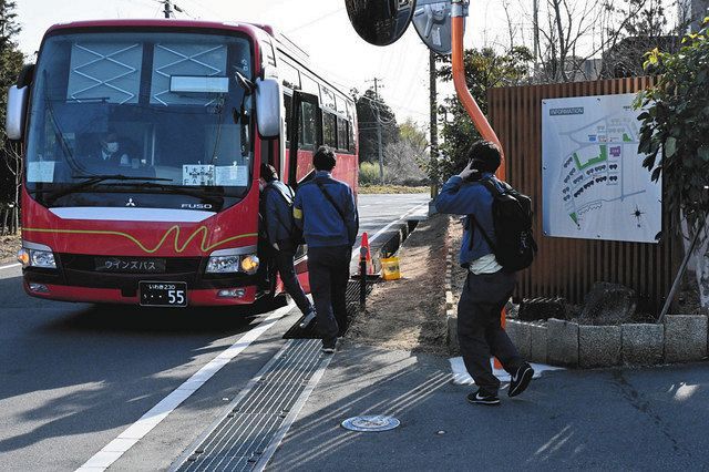福島第一原発を意味する「1F」と書かれたバスに乗り込む人たち＝福島県大熊町の東電社員寮前で