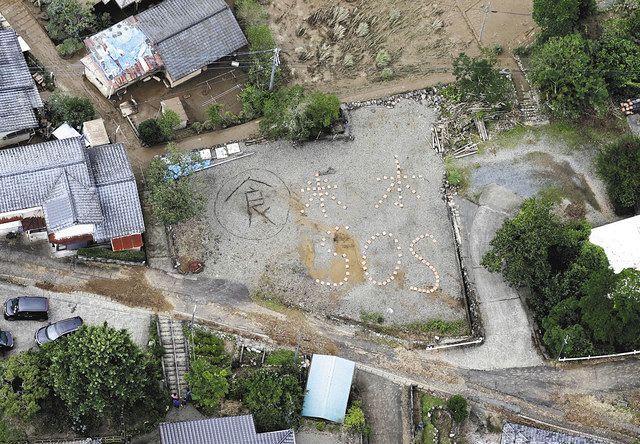 熊本県球磨村で地面に描かれた「米、水、ＳＯＳ」の文字＝５日午前１１時４９分
