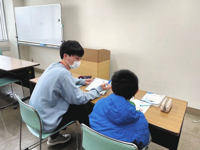 ボランティアで勉強を教えている菊水さん（左）＝川崎市高津区で