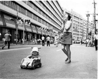 開放された車道の中央を乗り物で走る子供。母親は走るわが子の姿を見て大喜び＝１９７０年０８月２日、池袋東口で