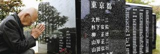 沖縄県糸満市の平和祈念公園で手を合わせる杉下さん。「平和の礎」には兄・安佑さんの名が刻まれている