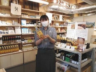 人気ナンバーワン「心の酢」を持つ、商品担当スタッフの近藤里紗さん＝東京都世田谷区で
