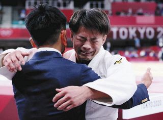 男子６６キロ級で優勝し、古根川実コーチ（左）と抱き合う阿部一二三＝いずれも日本武道館