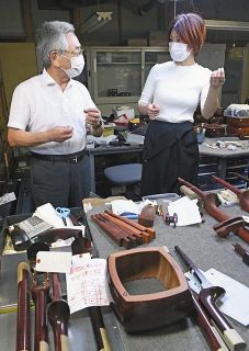大瀧勝弘代表（左）から工程について説明を受ける和楽器バンドの蜷川べに＝東京都八王子市で
