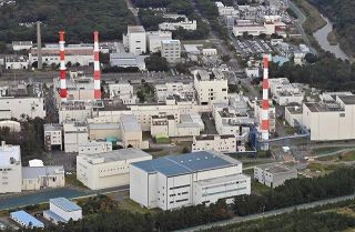日本原子力研究開発機構の東海再処理施設。高レベル放射性廃液貯槽がある建屋は、左側に見える赤白の排気筒２本の手前＝東海村で（本社ヘリ「おおづる」から）
