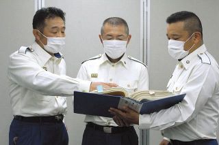 火災の資料を見ながら話す（左から）黒木征昭さん、菊池真紀夫さん、川越貴史さん＝東京消防庁で