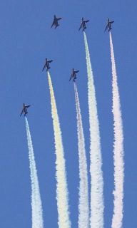 ５色のカラースモークを出しながら飛行する航空自衛隊の「ブルーインパルス」＝東京都新宿区の新宿御苑