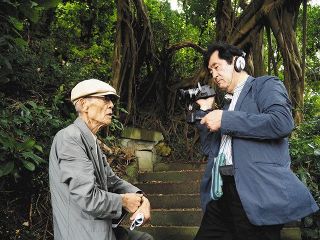 沖縄戦について語る森口さん（左）を撮影する永田さん＝２０１９年５月撮影