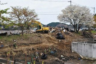 2011年5月、宮城県七ケ浜町で、池の土手のがれきを処理する人たち＝リファットさん提供