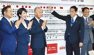 自民党本部の開票センター当確者の名前にバラを付ける岸田首相（右から２人目）
