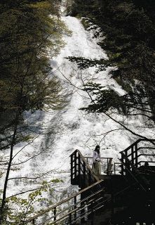 湯ノ湖から迫力のある音を立てて水が流れ落ちる湯滝
