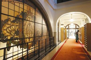 大きなステンドグラスやランプの明かりが歴史を感じさせる国会図書館国会分館の入り口。新聞のストックは廊下にまで並んでいた
