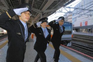 ＪＲ八王子駅で「東京アドベンチャーライン体操」の敬礼ポーズをする（右から）運転士の白尾さん、鍋島さん、関根さん
