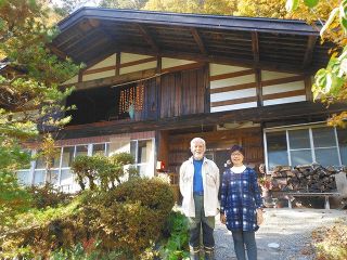 民宿と大瀧さん夫妻。２階には柿が干されていた