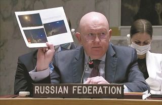米ニューヨークで11日、国連安保理の緊急会合に出席して「資料」を掲げ演説するロシアのネベンジャ国連大使＝ＡＰ