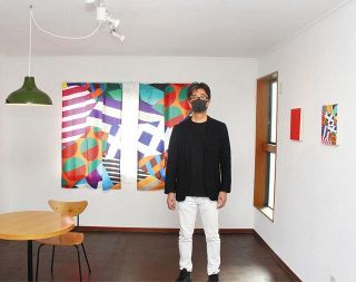 カーテンと同じ柄の絵で全体が一つの作品となった部屋を紹介する長田さん

