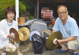使われなくなった楽器を持つ岩井光祐さん㊨と日比野由貴子さん＝神奈川県南足柄市で