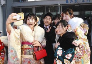 幼なじみたちとスマホの写真に納まる須崎優衣さん（左）＝松戸市で