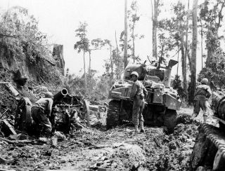 レイテ島オルモックで、米軍の戦車を盾に進む歩兵部隊＝１９４５年１月、米陸軍通信隊撮影（ＡＣＭＥ）
