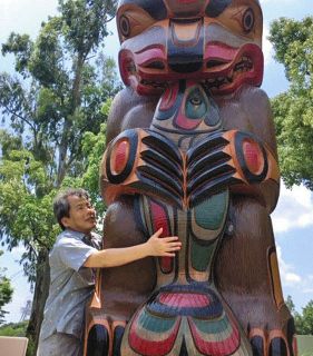 触る展示の一つ、トーテムポールを触る広瀬浩二郎さん＝大阪府吹田市の国立民族学博物館で
