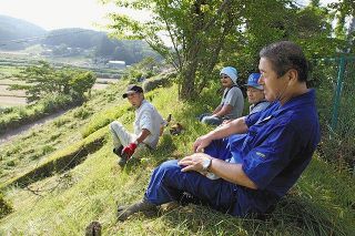 避難指示が続く間も、長谷川健一さん（手前）は集落の草刈りを欠かさなかった＝２０１６年８月７日、飯舘村で（豊田直巳さん提供）
