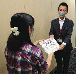 署名を亀田製菓の担当者に手渡す女子生徒（左）