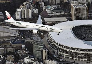 羽田新ルートの飛行確認のため、都心上空を飛行する旅客機＝２月撮影