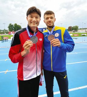 昨年8月、世界デフ陸上選手権の200メートルで2位となり3位のウクライナ選手と記念撮影した山田真樹選手㊧＝ポーランドで（日本デフ陸上競技協会提供）