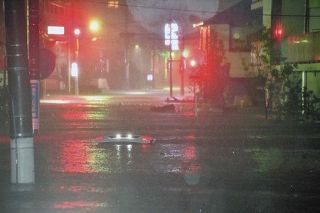 冠水した道路で水没した車＝１２日午後８時４７分、世田谷区玉堤で