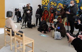 展示作品の「平和の少女像」㊧を撮影する報道陣。延期されていた東京展の初日は国内外の多数のメディアが取材した＝東京都国立市で